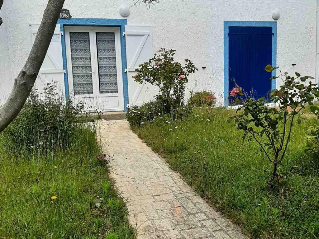 un sentiero in mattoni davanti a una casa con una porta blu di Maison Locmaria, 3 pièces, 4 personnes - FR-1-418-145 a Locmaria