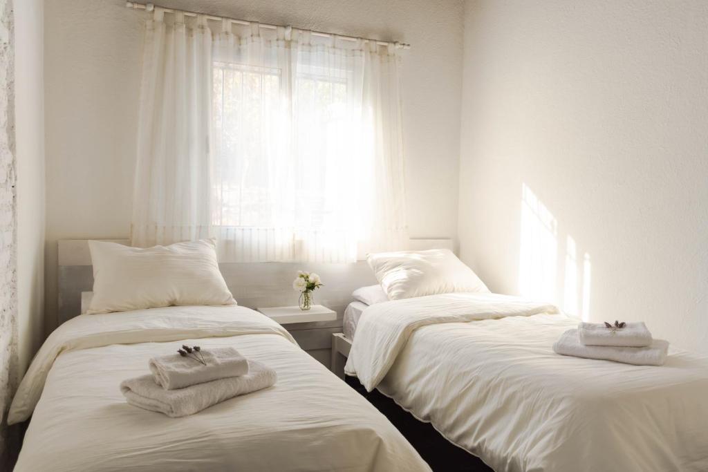 zwei Betten in einem Zimmer mit Handtüchern darauf in der Unterkunft El Bonito Salta in Salta