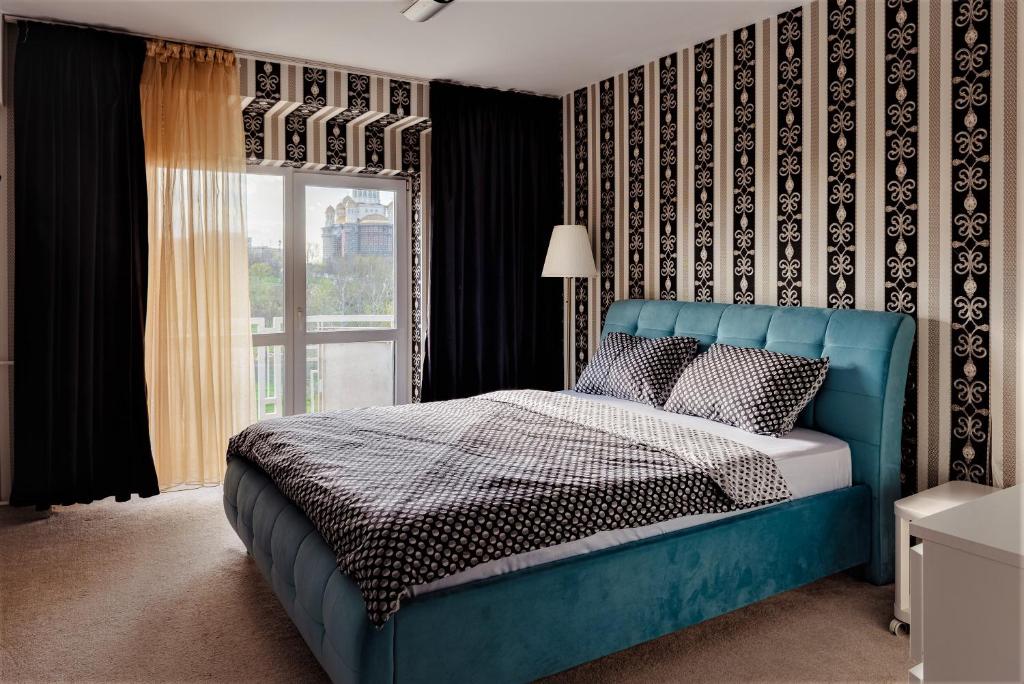 a blue bed in a room with a window at Parliament Merlot Unirii Square 5 Bedrooms Luxury Apartment Old Town in Bucharest