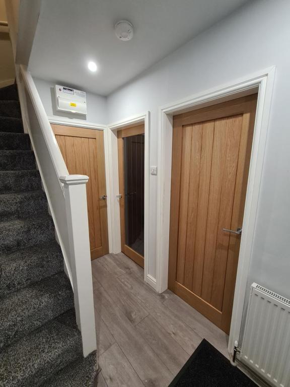 Hotel Whole House - 4 Bedrooms - Parking - Sleeps 8, a hallway with two wooden doors and stairs at Whole House - 4 Bedrooms - Parking - Sleeps 8 in Birmingham