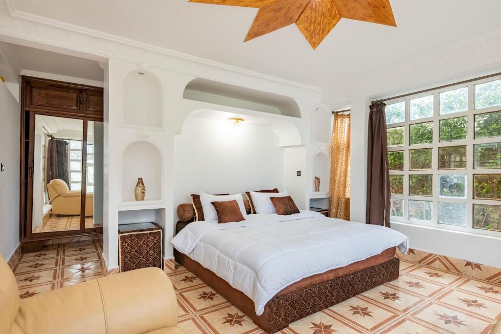 ein Schlafzimmer mit einem großen Bett und einem großen Fenster in der Unterkunft Chambre d'hôte Azemmour in El Jadida