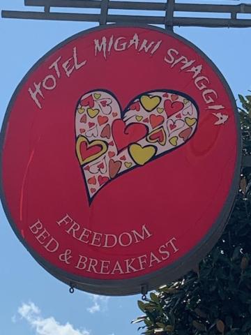 un panneau rouge avec deux cœurs et les mots “redleton” et “breakfast” dans l'établissement Hotel Migani, à Rimini