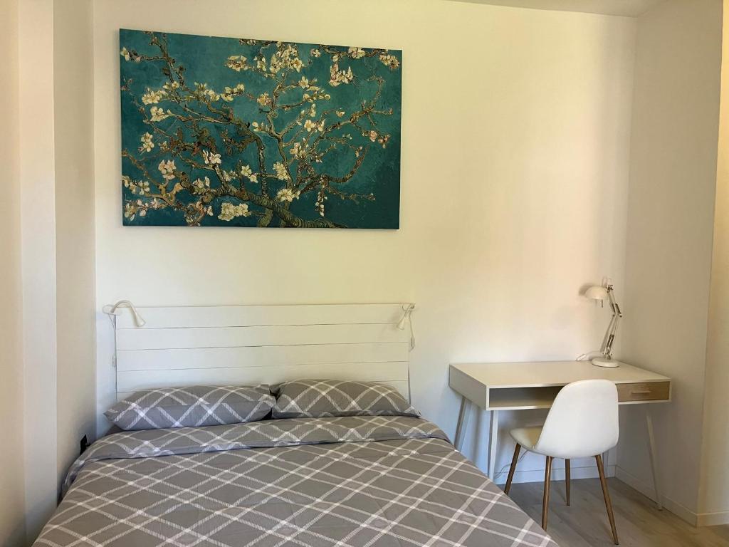 um quarto com uma cama, uma secretária e um quadro em Casa di Arianna in centro storico a Vimercate em Vimercate