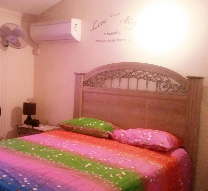 1 dormitorio con 1 cama con cabecero de madera en JA-Spain Retreat, en Spanish Town