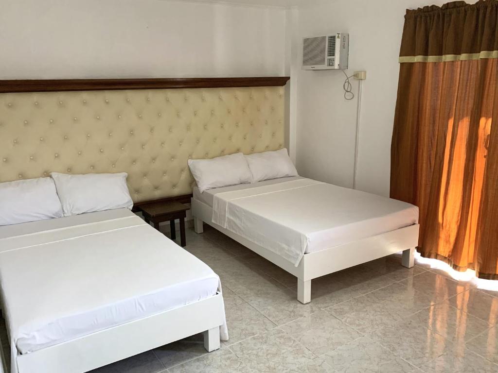 two beds in a small room with at Culpepper Lodge in Aklan
