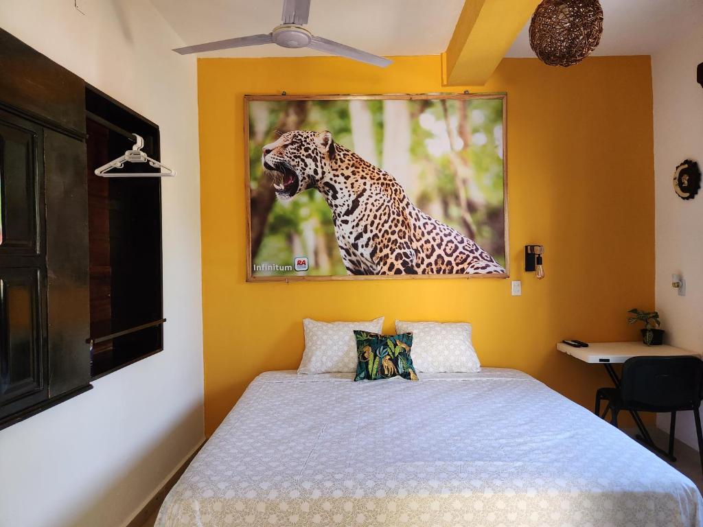 una camera con un letto e un dipinto di una giraffa di LoftJaguar a Palenque