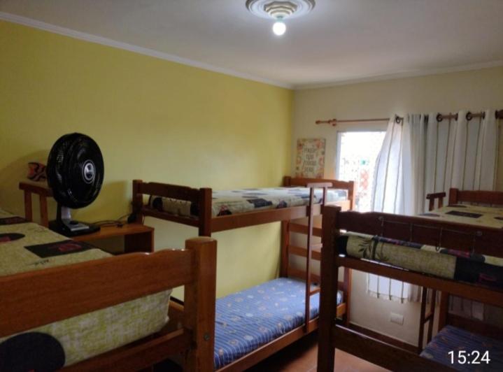 a room with three bunk beds and a window at Acolhedor com suíte e wi-fi in Praia Grande