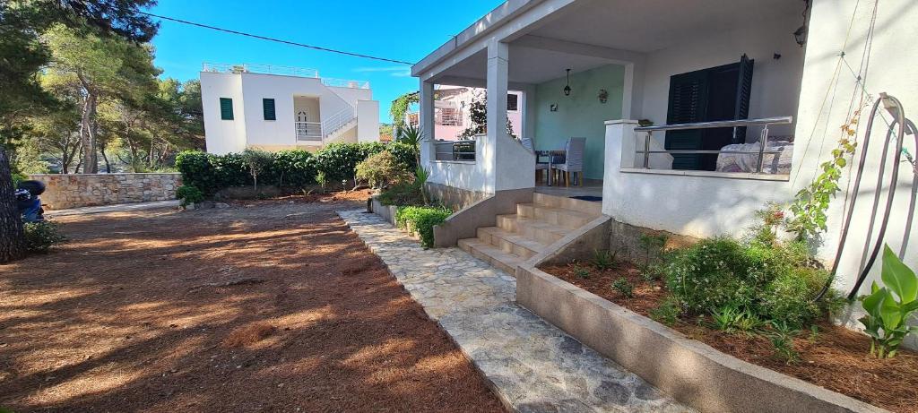 une maison avec des escaliers et une terrasse couverte avec une clôture dans l'établissement Apartments Antica, à Basina