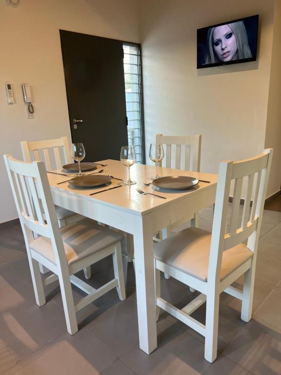 a table with chairs and a white table and a tv at Lautaro in San Juan