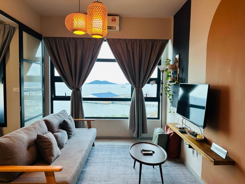 a living room with a couch and a large window at Jesselton Quay - Suite 1 by Staycation Suites KK in Kota Kinabalu