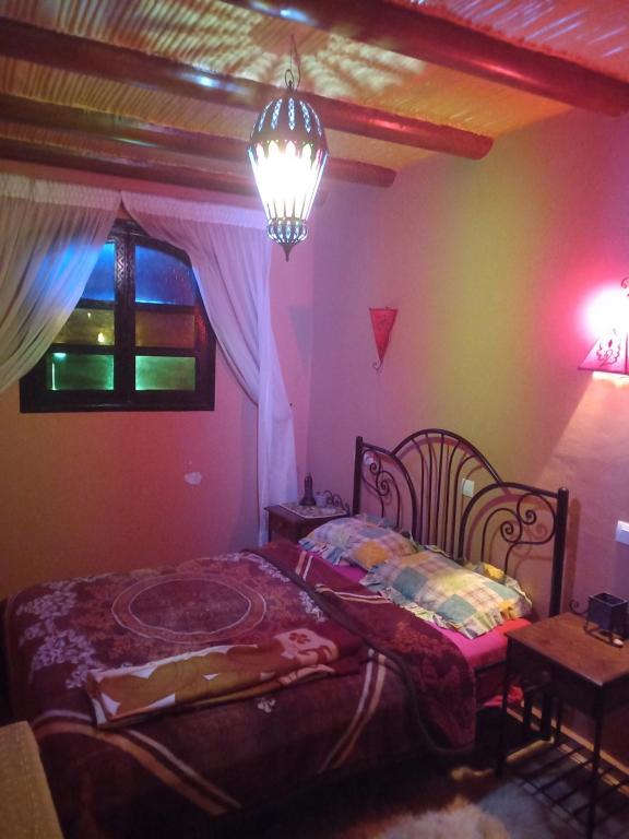 Schlafzimmer mit einem Bett, einem Tisch und einem Fenster in der Unterkunft berber house in Taourirt