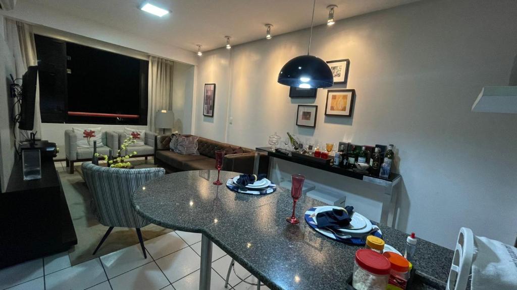 uma cozinha com uma mesa e uma sala de estar em Flat 203 Clarice Lispector, Ilhotas- Teresina em Teresina