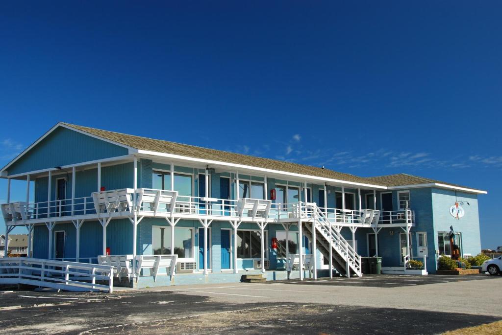 un gran edificio azul con porche y escaleras en Fin 'N Feather Waterside Inn by Kees Vacations en Nags Head