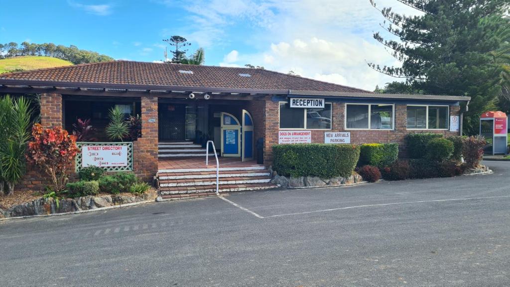 a brick building with a sign in front of it at Banana Coast Caravan Park in Coffs Harbour