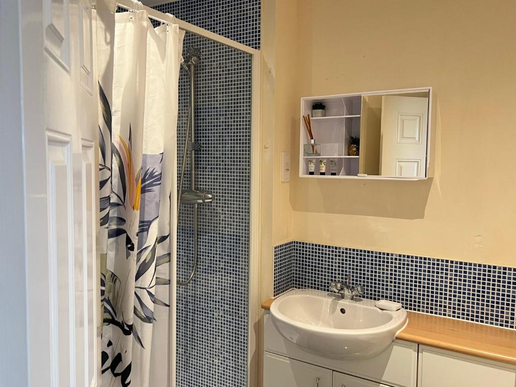 a bathroom with a sink and a shower at Radiant2 bedroom apartment in the heart of Harlow town in Harlow