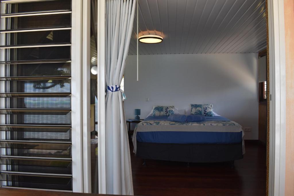 a bedroom with a bed next to a window at Fare Aute Beach in Vaianae