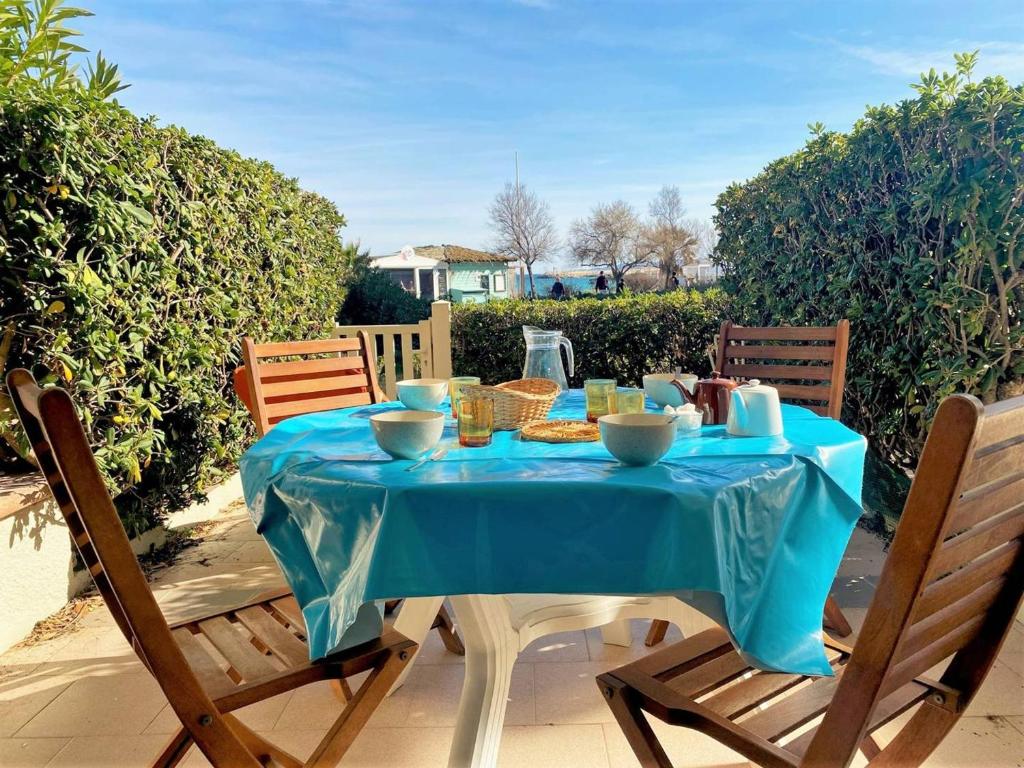 una mesa con un mantel azul en el patio en Appartement Le Lavandou, 2 pièces, 4 personnes - FR-1-251-454, en Le Lavandou