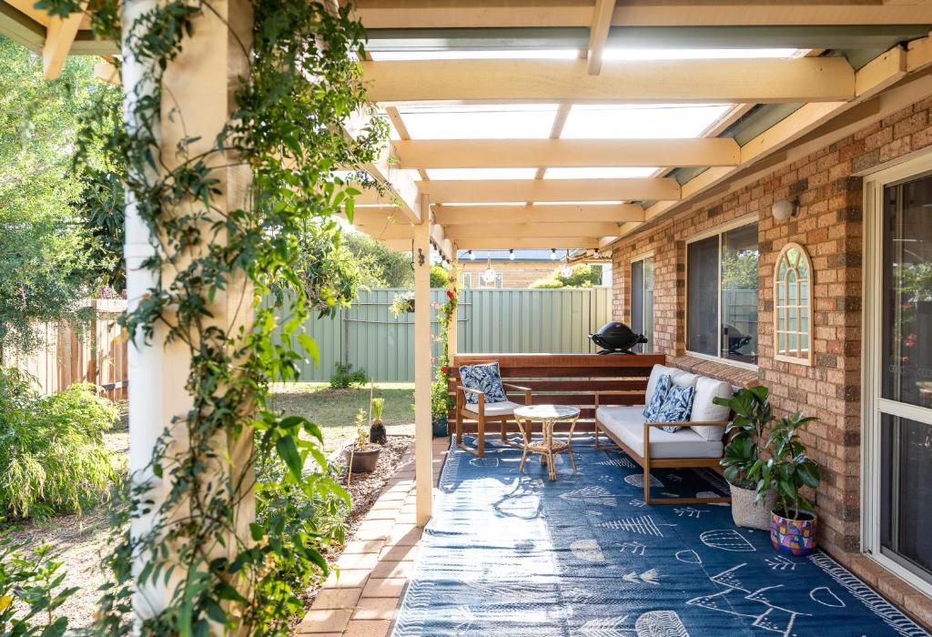 an outdoor patio with a pergola and a bench at Double J's in Margaret River Town
