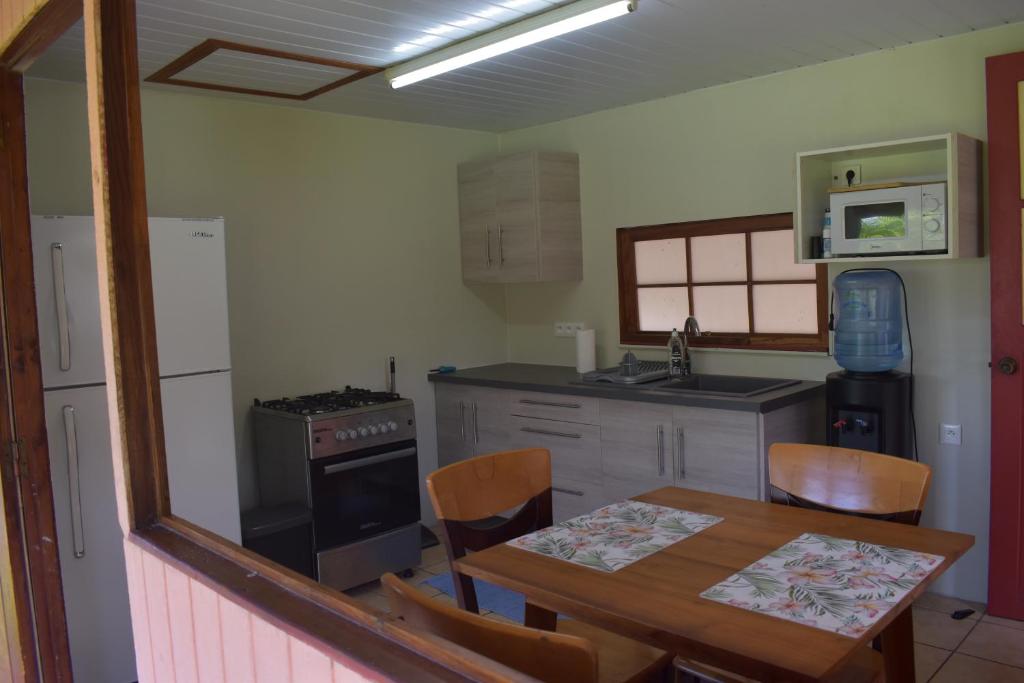 a kitchen with a wooden table and a dining room at Fare Aute Beach in Vaianae