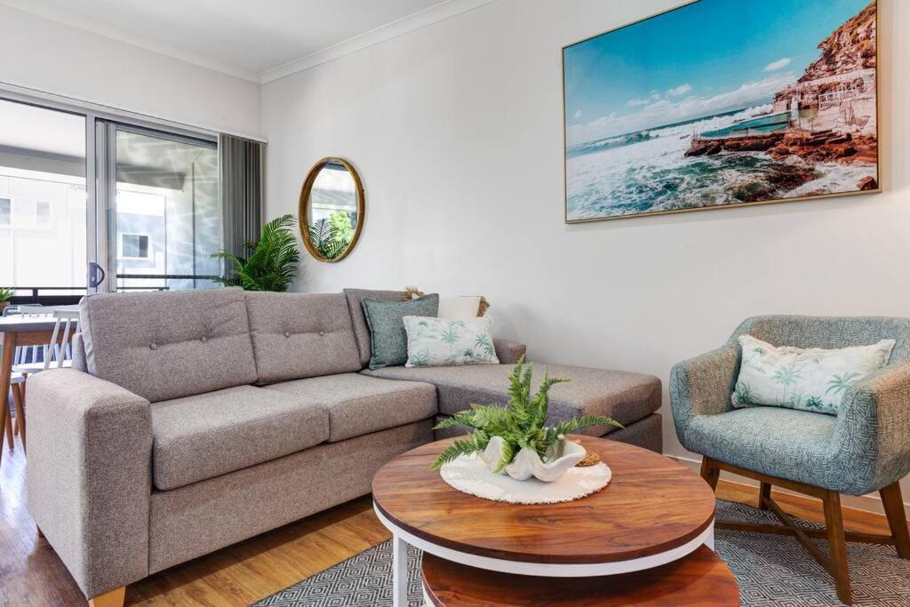 a living room with a couch and a table at MARJ12- Stylish and Spacious in Mooloolaba