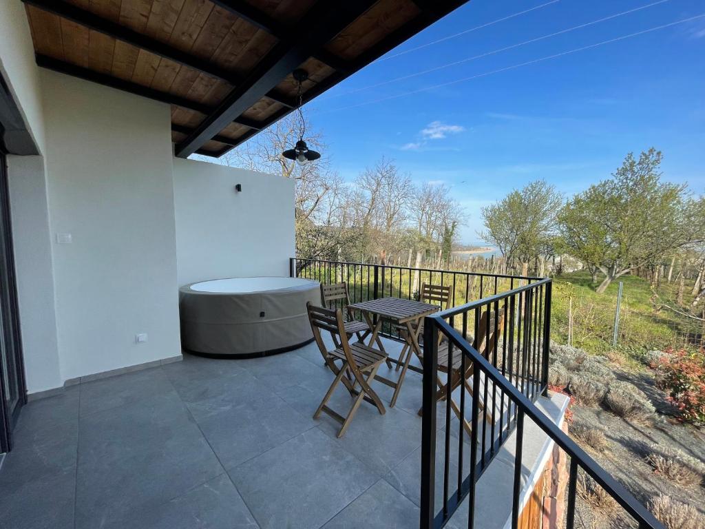 a patio with a table and chairs on a balcony at Rózsakő Ház in Badacsonytomaj