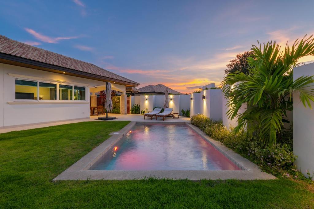 a backyard with a swimming pool and a house at Orchid Paradise Homes OPV422 in Hua Hin