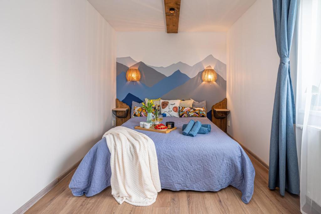 Un dormitorio con una cama azul con montañas en la pared en Family Garden Apartments with Free Private Parking & Playground, en Riga