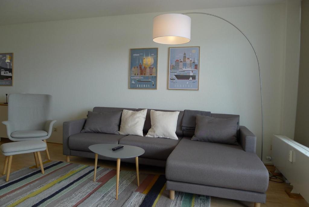 a living room with a couch and a table at Panorama Whg 73, 5 OG in Cuxhaven