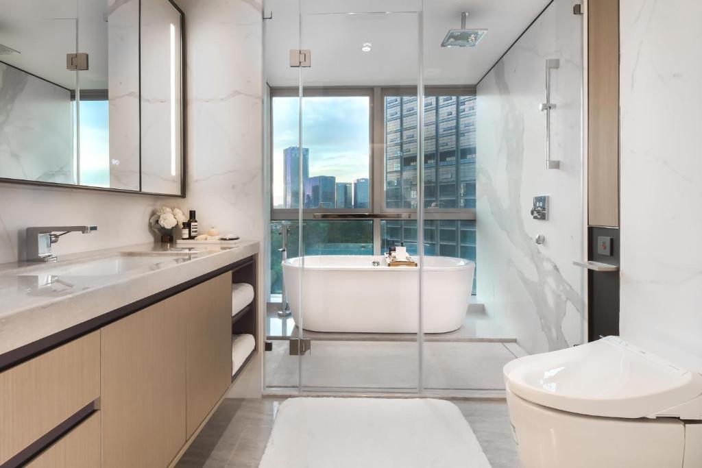 La salle de bains est pourvue d'une baignoire, d'un lavabo et de toilettes. dans l'établissement Artisse Place - Access to 4000 sqm Fusion Wellness Centre and 800 sqm Indoor Swimming Pool, à Shenzhen