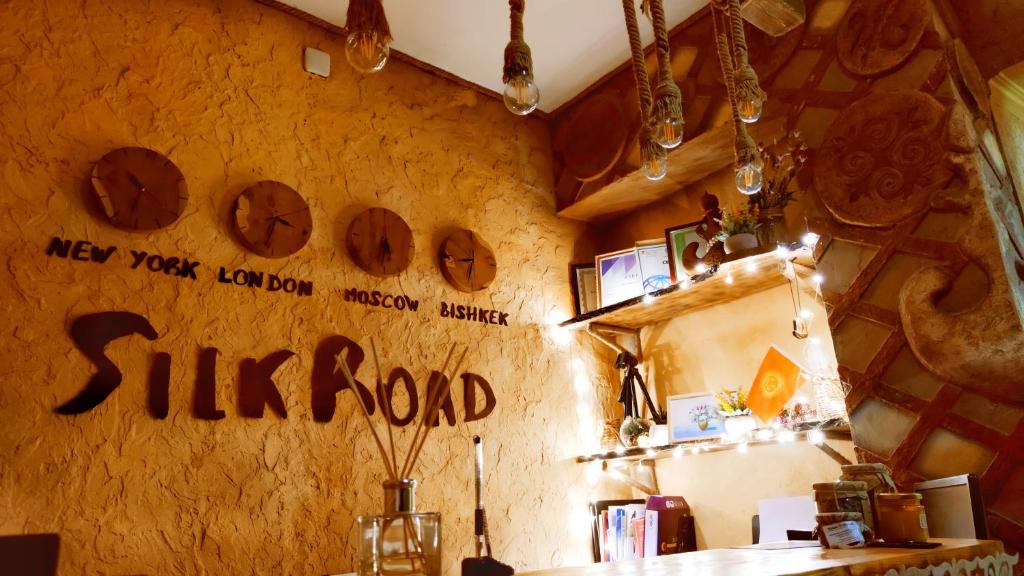 SilkRoad Guesthouse في بيشكيك: مطعم مع لافتة تقول طريق الغناء على الحائط