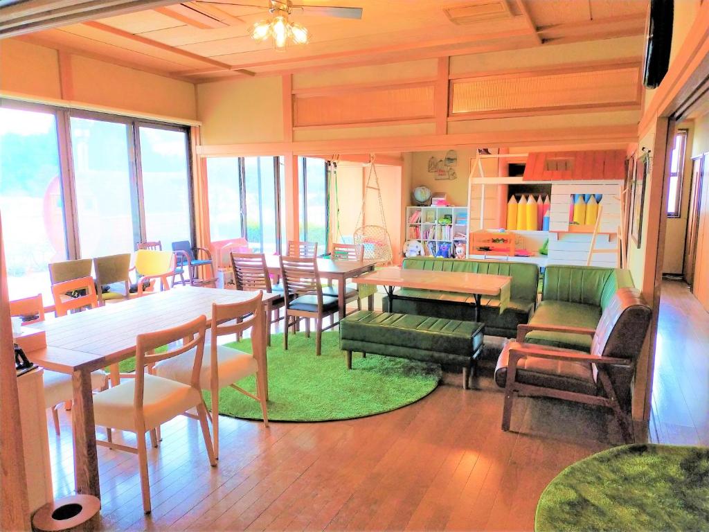 a room with tables and chairs and a dining room at ゲストハウス　アンブレラ in Soma