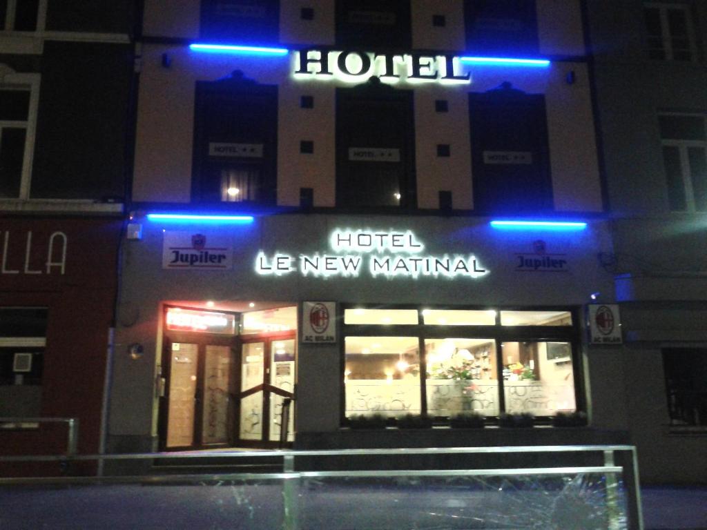 a hotel with blue lights in front of a building at Le New Matinal in La Louvière