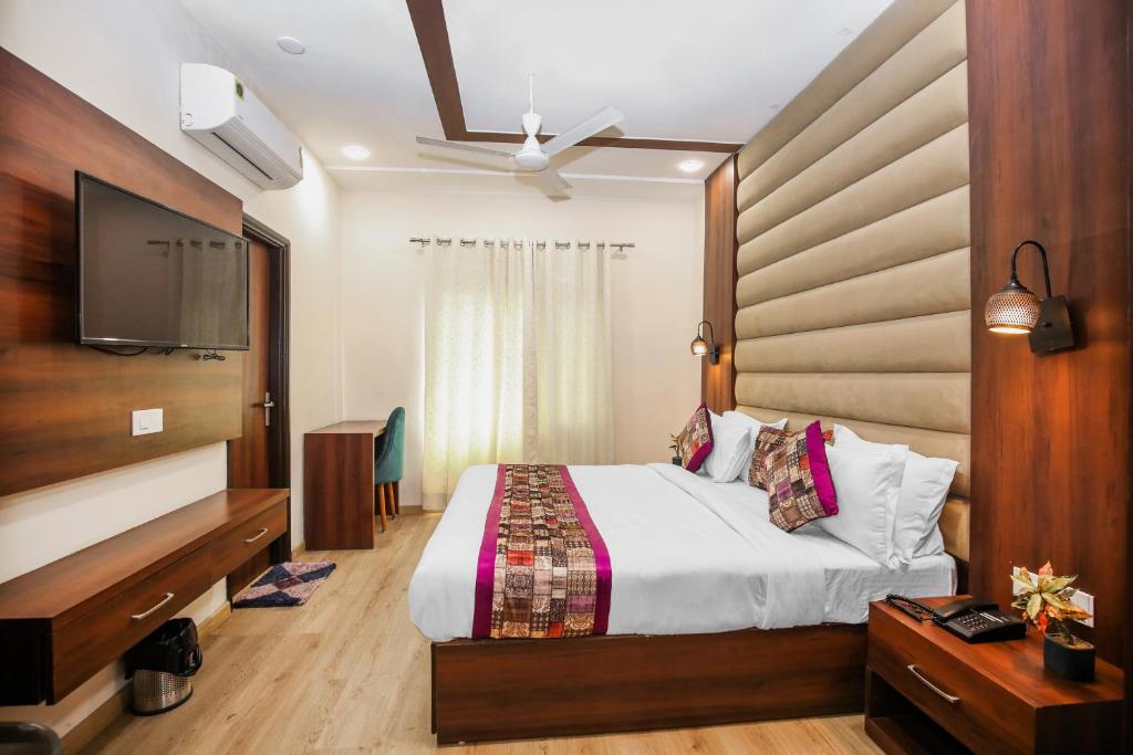 a bedroom with a bed and a flat screen tv at Hotel Karan Residency Amritsar - Golden Temple in Amritsar