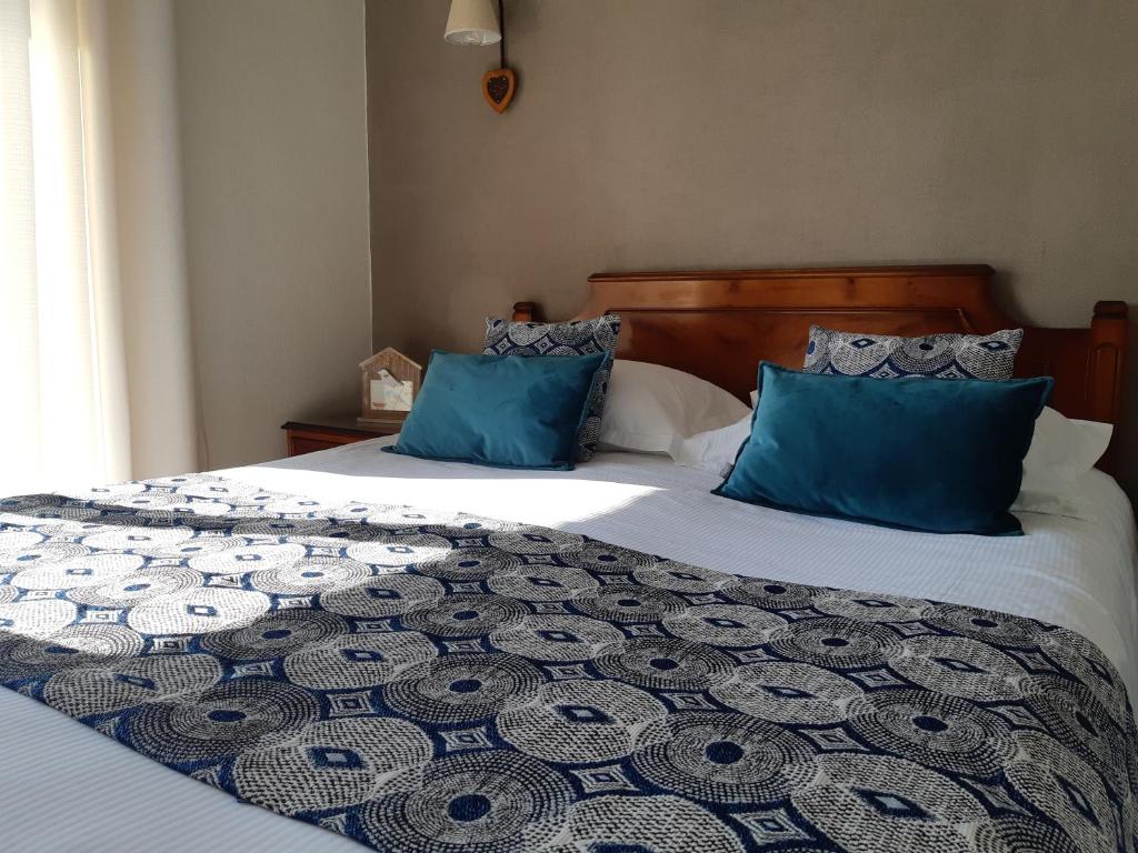 a bedroom with two beds with blue pillows at Les Alpages in Bonlieu