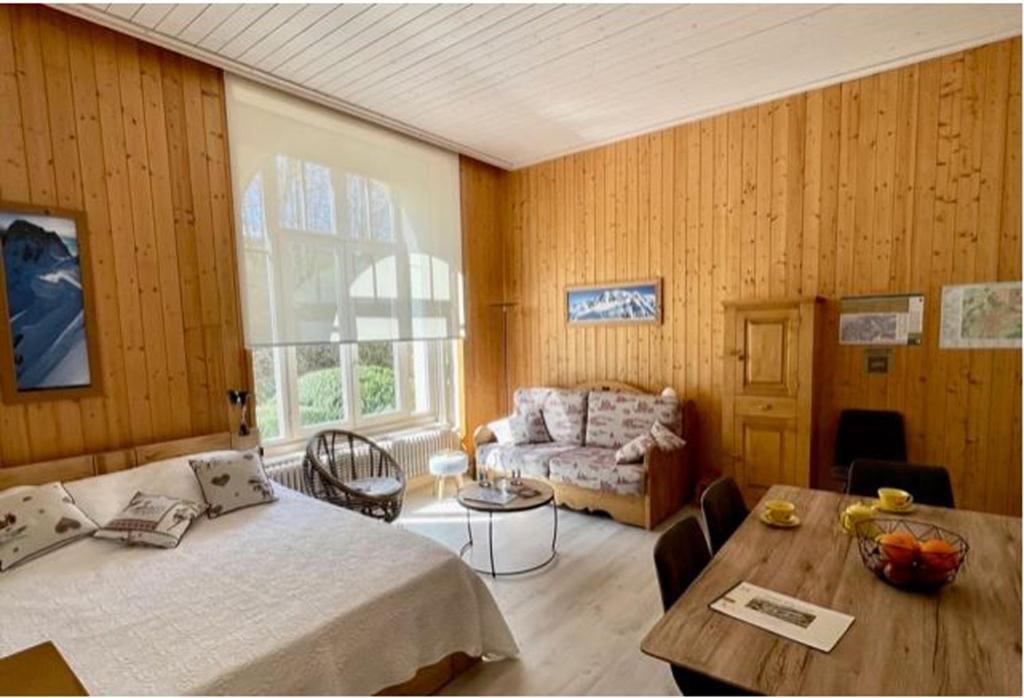 une chambre avec un lit, une table et un canapé dans l'établissement Résidence du Mont-Blanc n°5Bis, à Combloux