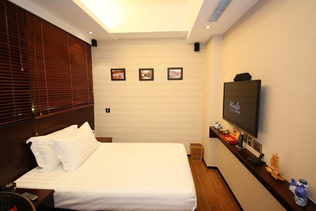 a bedroom with a bed and a flat screen tv at The Shai Red - formerly Mingle in The Shai in Hong Kong