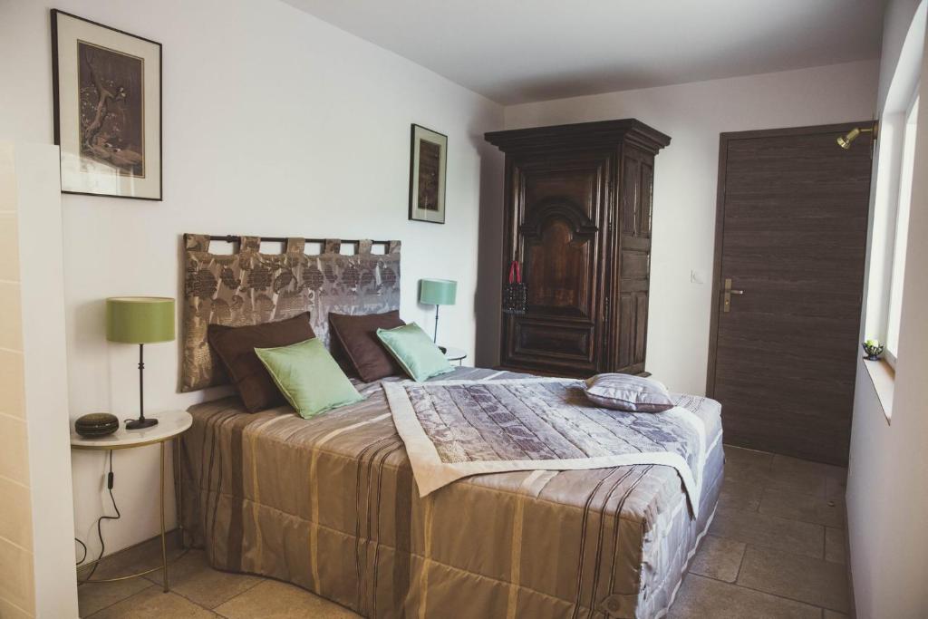 a bedroom with a large bed with a wooden headboard at LES CENT CIELS in Salavas