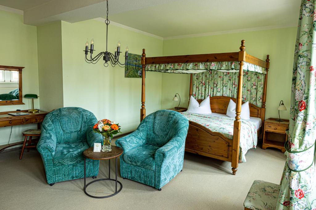 a bedroom with a canopy bed and two chairs at Hotel Anker in Saalfeld