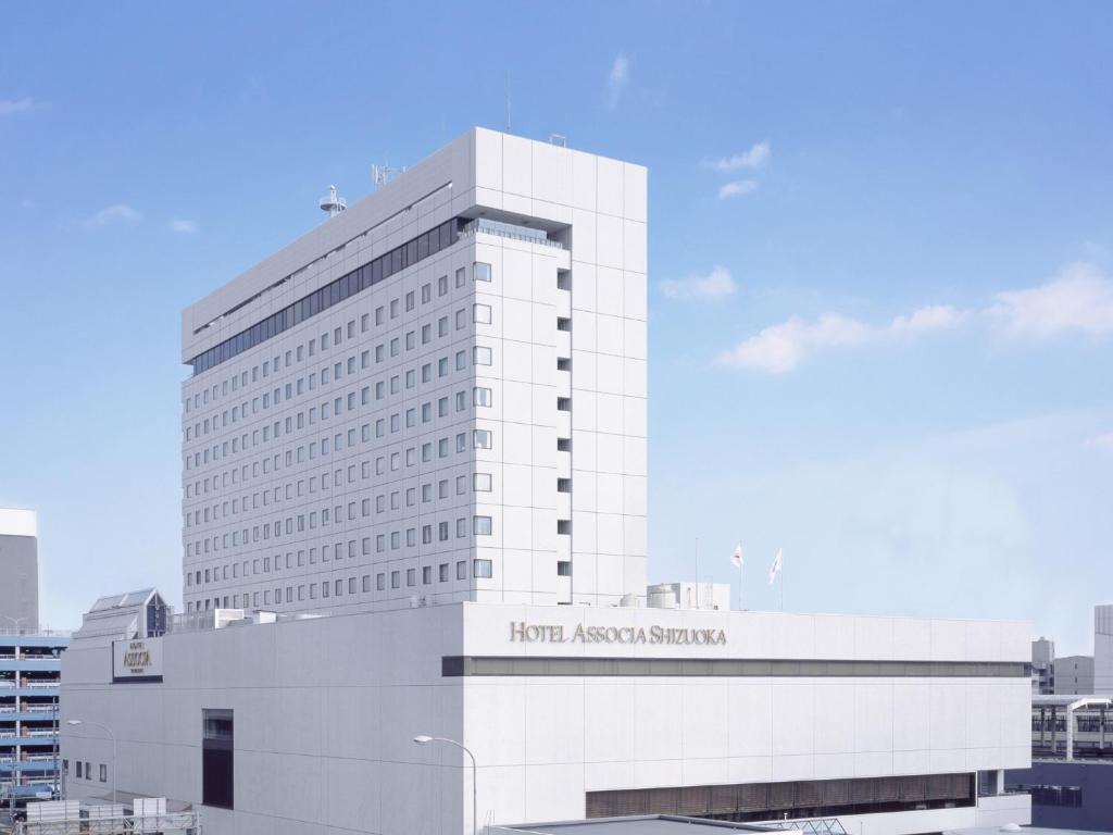 un gran edificio blanco con un cartel. en Hotel Associa Shizuoka, en Shizuoka