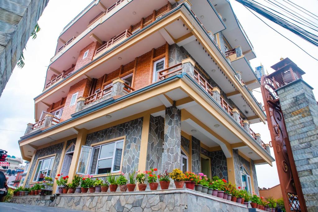 een gebouw met bloempotten aan de voorzijde bij Hotel Olympus Pokhara in Pokhara