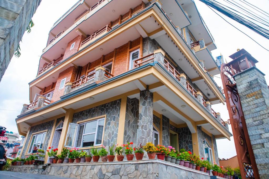 un edificio con macetas en la parte delantera en Hotel Olympus Pokhara, en Pokhara