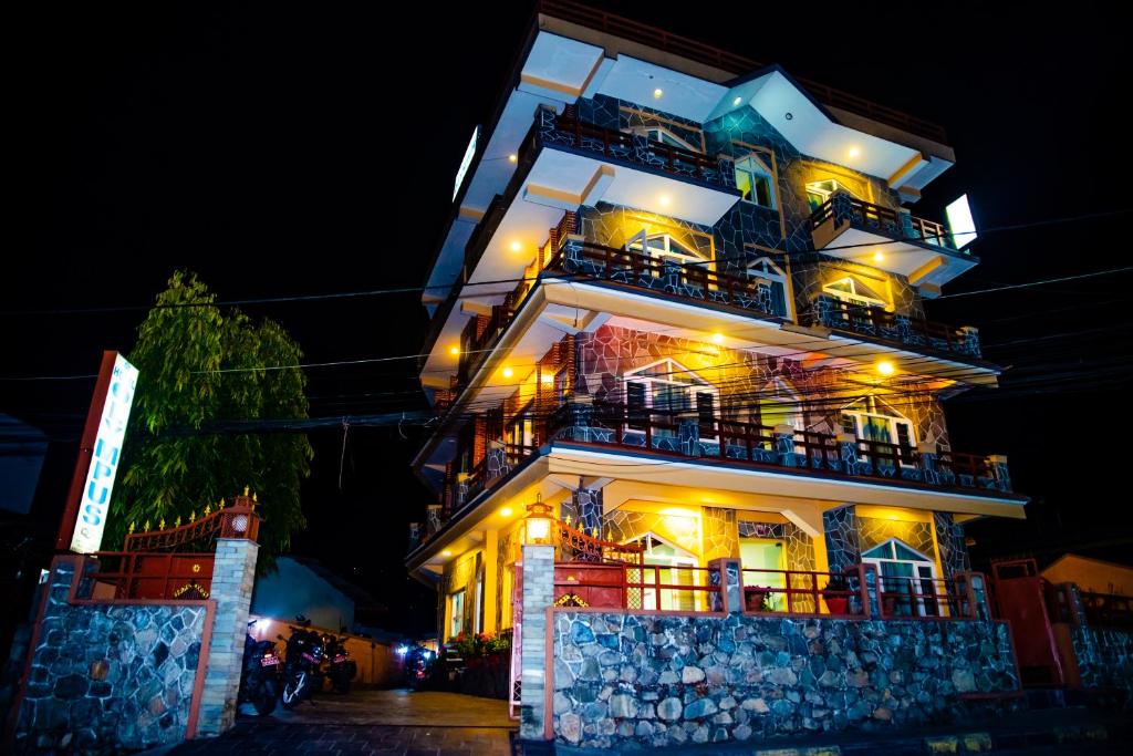 un edificio alto con balcones y luces. en Hotel Olympus Pokhara, en Pokhara