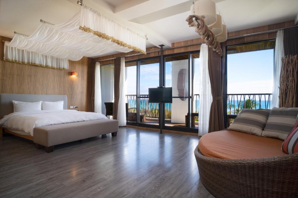 una camera con letto, divano e finestre di 畫日風尚會館Sinasera Resort a Changbin