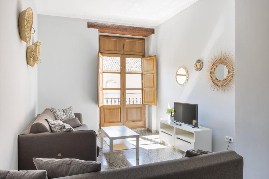 uma sala de estar com um sofá e uma televisão em Macflats Valencia Puerto em Valência