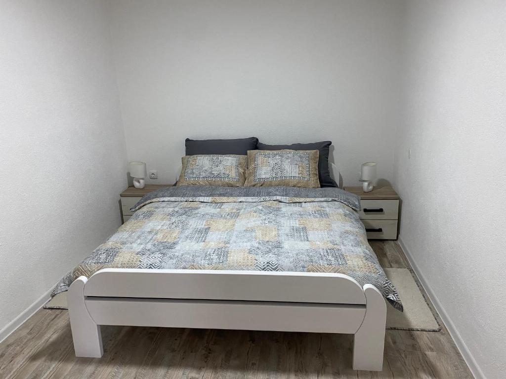 1 dormitorio con 1 cama con 2 mesitas de noche en Apartman Downtown, en Bosanski Novi