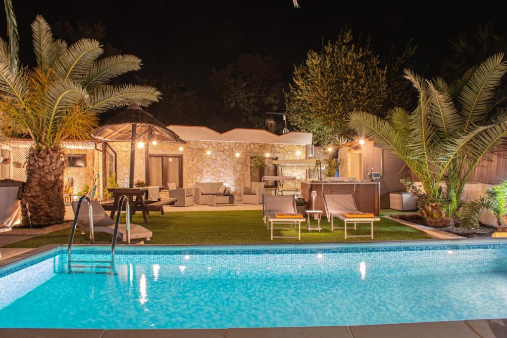 a backyard with a swimming pool and a house at Villa Tore in Quartu SantʼElena