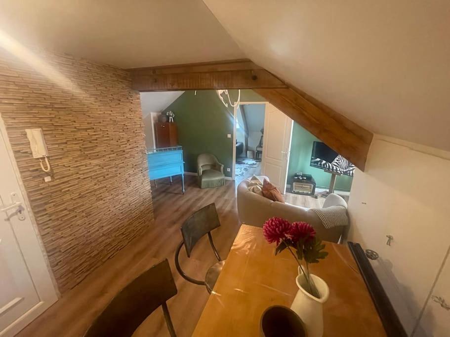 ein Wohnzimmer mit einem Tisch und einer Blumenvase darauf in der Unterkunft Appartement Cosy et charmant in Saint Lo