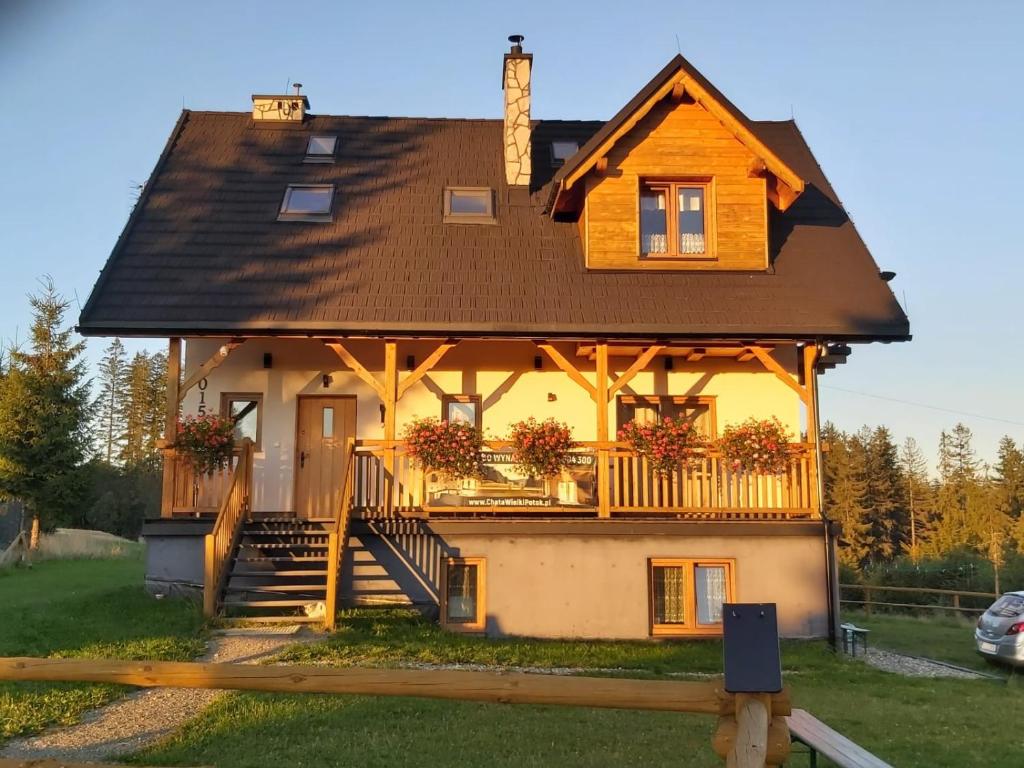 a house with a gambrel roof and a porch at Chata Wielki Potok in Istebna