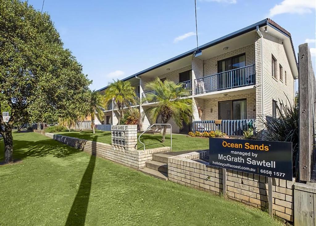 un edificio con un cartello di fronte a un cortile di Ocean Sands 5 a Sawtell