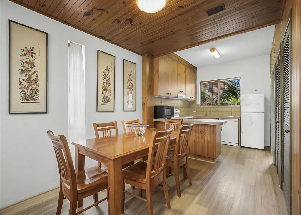 a kitchen and dining room with a wooden table and chairs at Banksia in Sawtell